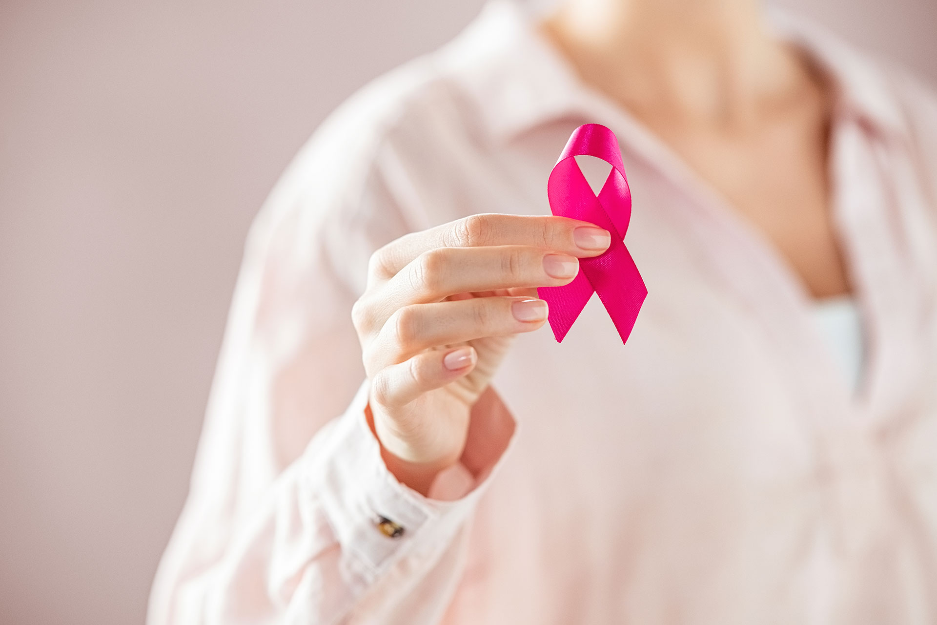 Woman holding pink breast cancer ribbon